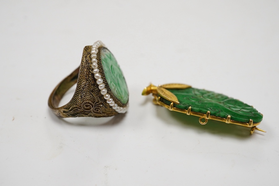 A Chinese yellow metal mounted carved jade leaf brooch, stamped 'TC18', 36mm, gross weight 5.6 grams and a jade and seed pearl set filigree ring. Condition - fair to good